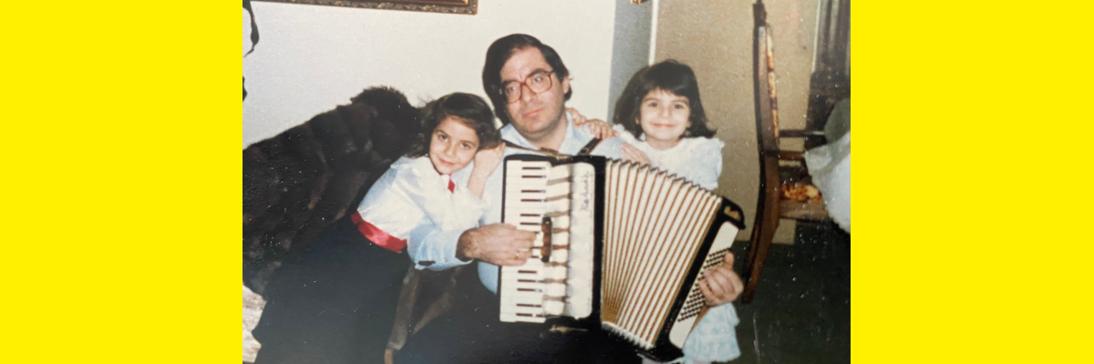 Une photo de la fin des années 80. Dimitrios joue de l'accordéon. Une jeune Angela est assise à gauche. Sa sœur est assise à droite. 
