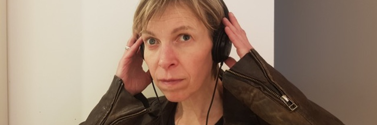 an image of Alex with earphones on smiling