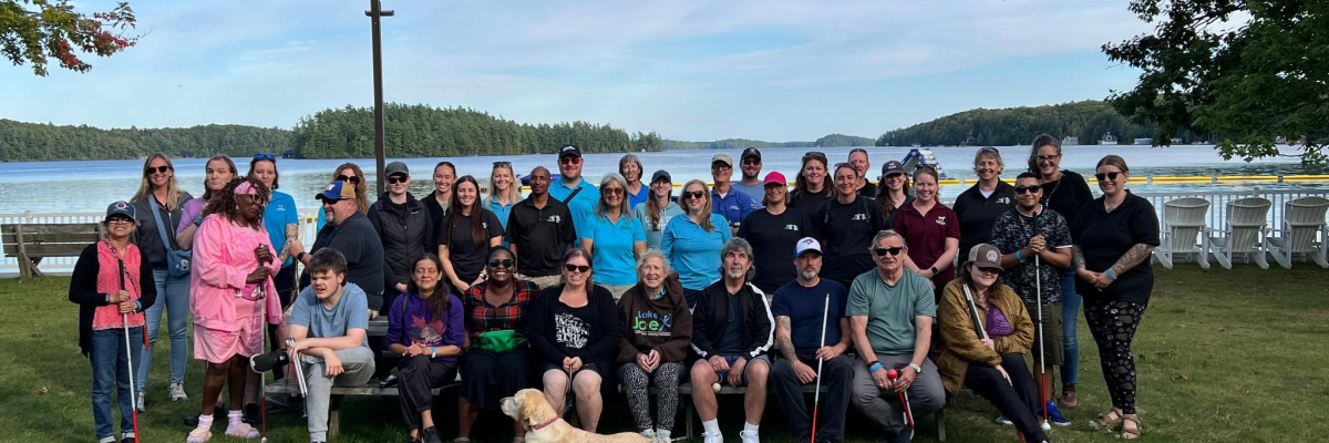 Program attendees and staff posing on the grass at Lake Joe.