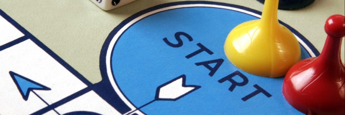 Board game with two colourful game pieces on a blue circle with the word "START"