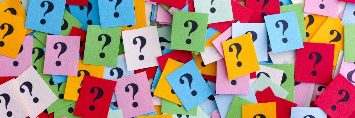 Lots of colourful post-it notes spread out, all with question marks on them.