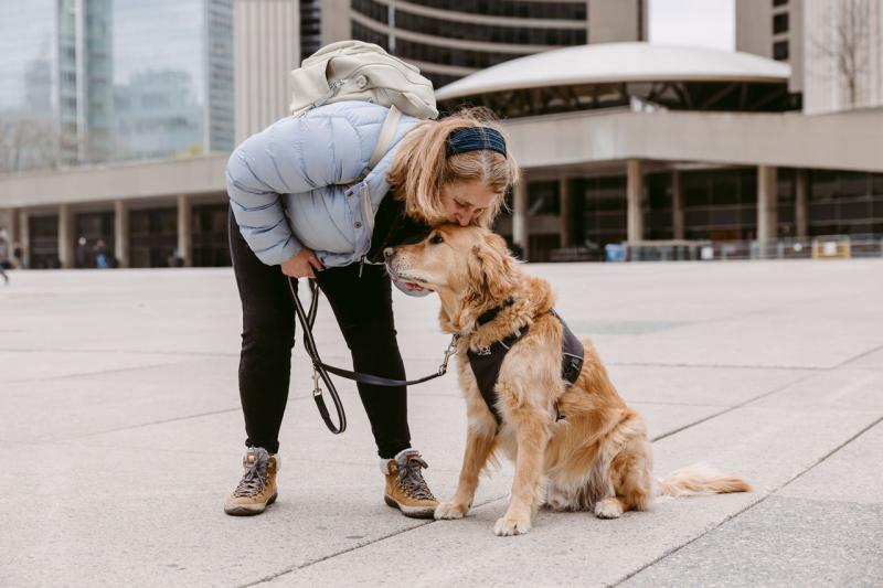 Lindsay bending down to kiss the top of Charles' head.