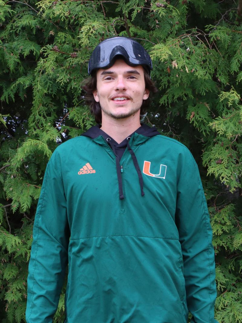 Chayse Zehr stands in front of a green tree while wearing athletic clothing and eye shades.