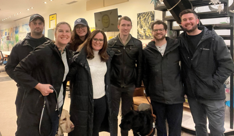 A group photo of Larissa and Shannon (front left) with Jack, a guide dog handler featured in the Ontario Police video, and four members of the video production crew, at the CNIB GTA Community Hub. Larissa and Jack are accompanied by their guide dogs.