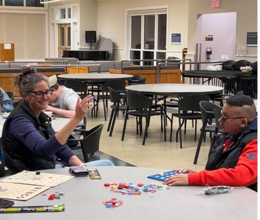 Sarah (left) smiles warmly while assisting a guest during Bingo Night at CNIB Lake Joe.