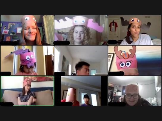 A screenshot of a virtual Lake Joe event wherein nine people with various skin tones - each appearing on their own camera from home - are wearing homemade paper hats.
