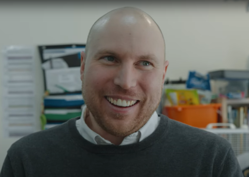Matt, Coordinator of Annual Giving and Stewardship and CNIB Come to Work participant, smiles indoors in an office setting.