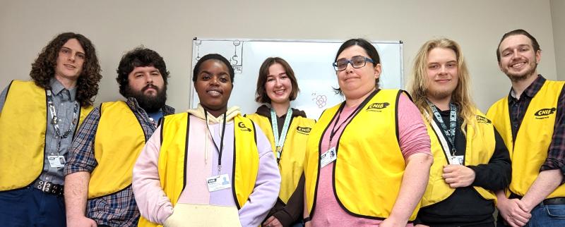 A group of canvassers standing with CNIB vests on.