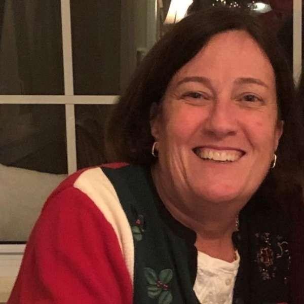 Stephanie Wilsack wearing a Christmas sweater and smiling.