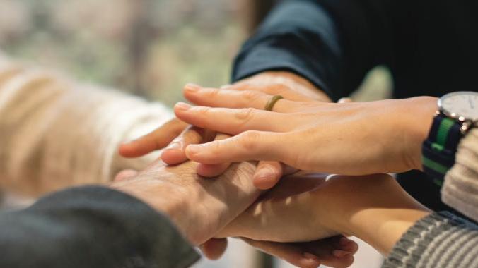 hands stacked on top of each other in a circle