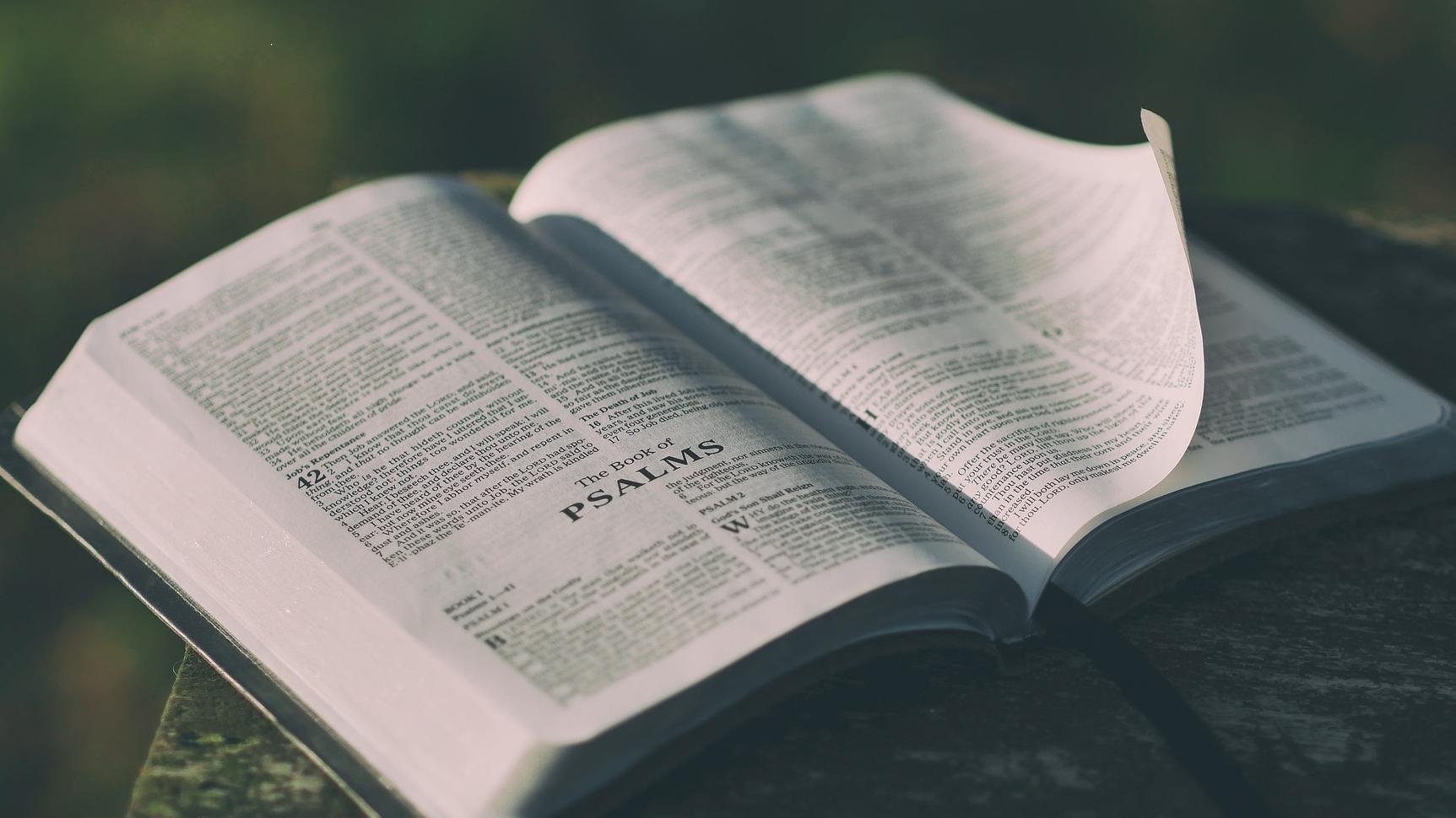An open bible sits on a table. 