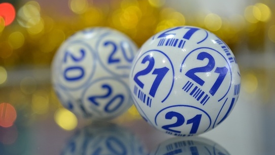 Two  bingo balls imprinted with numbers and letters used in the selection process of a bingo game.