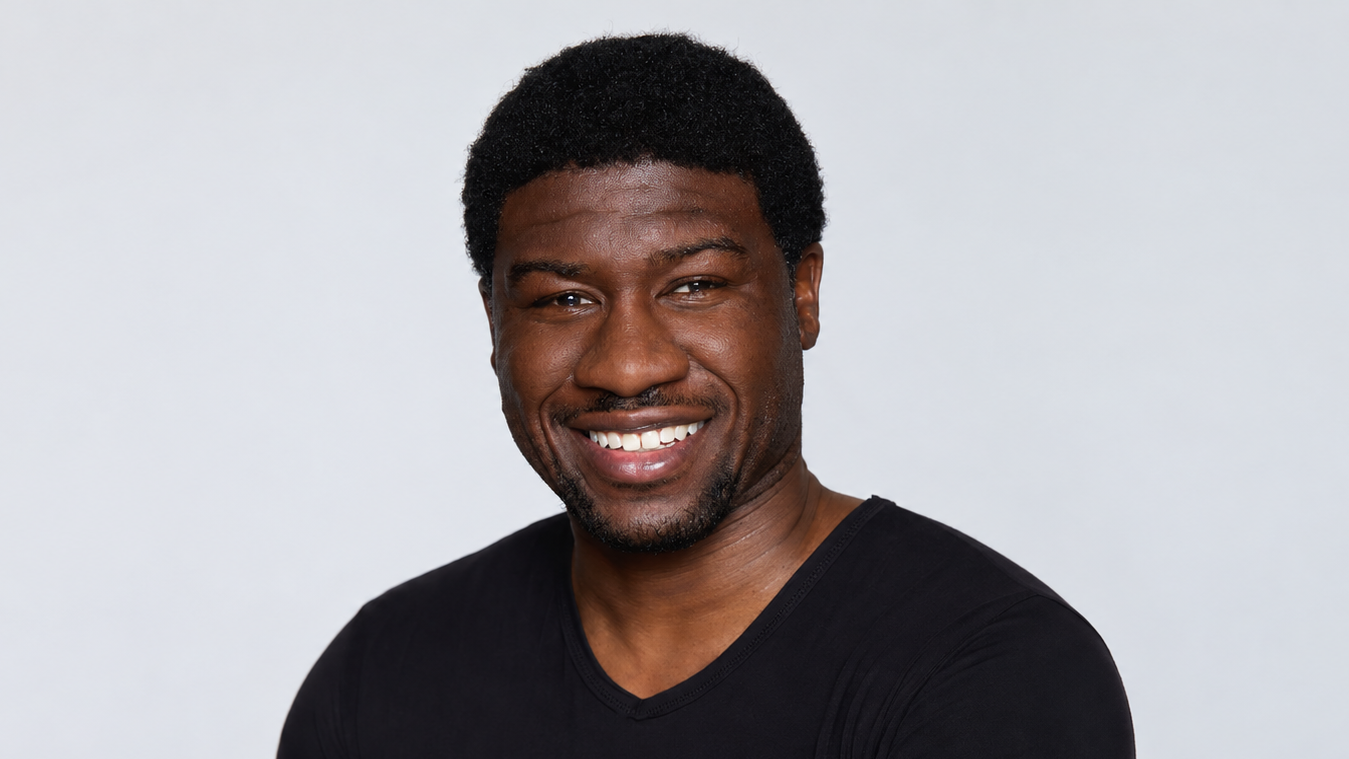 Ben Akuoko, a man with dark skin wearing a black t-shirt, smiles for the camera