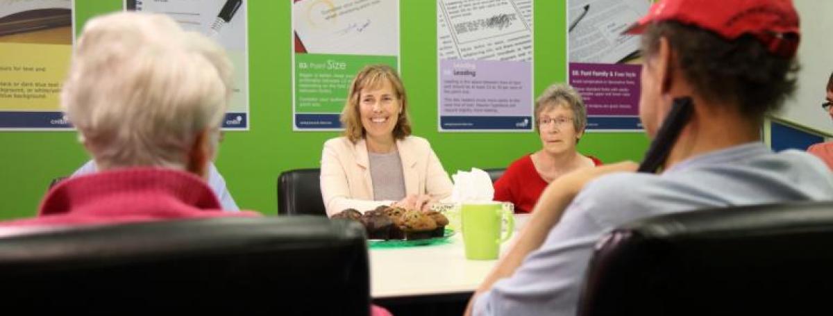 A group of four people sit at a table and engage in lively conversation. 