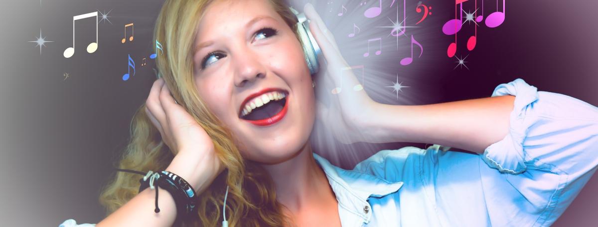 Young woman smiling holding headphones to her ears. There are musical notes floating around her.