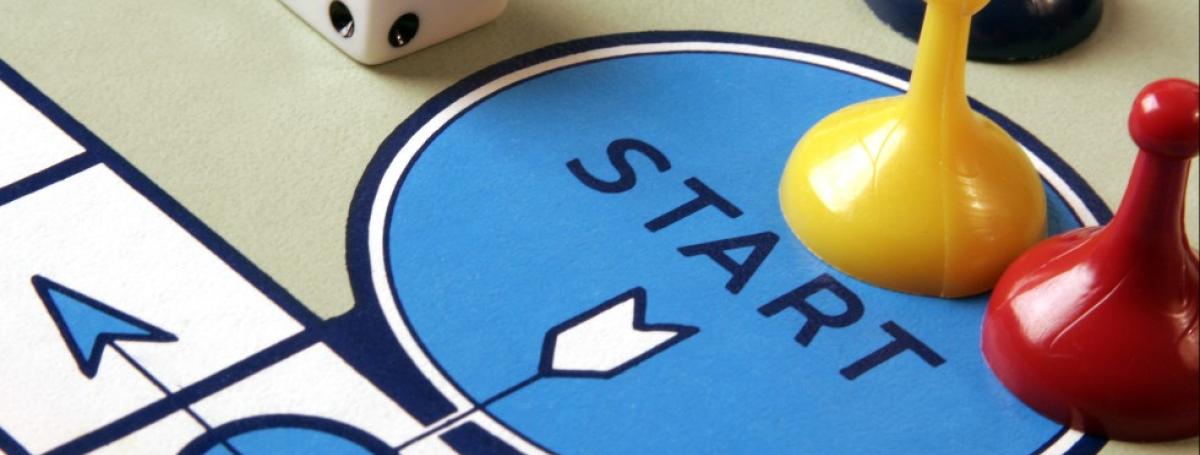 Board game with two colourful game pieces on a blue circle with the word "START"
