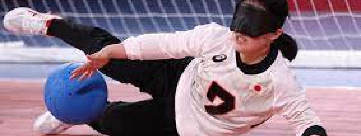 Woman wearing eye mask diving across the floor to catch ball in goalball