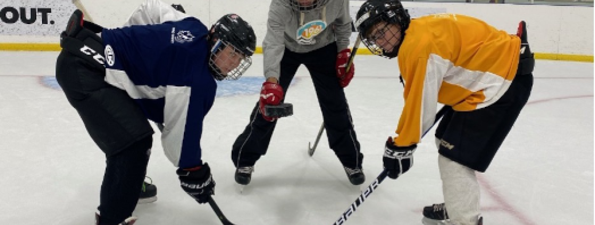 A puck drop. Hockey players, Brayden, Mathew and Eli during practice on the rink.