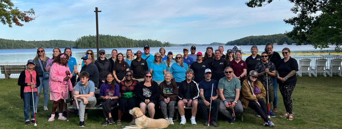 Program attendees and staff posing on the grass at Lake Joe.