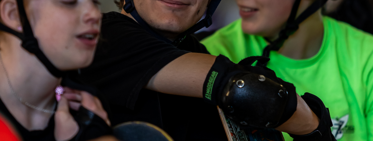  Skateboarders smiling wearing their helmets.
