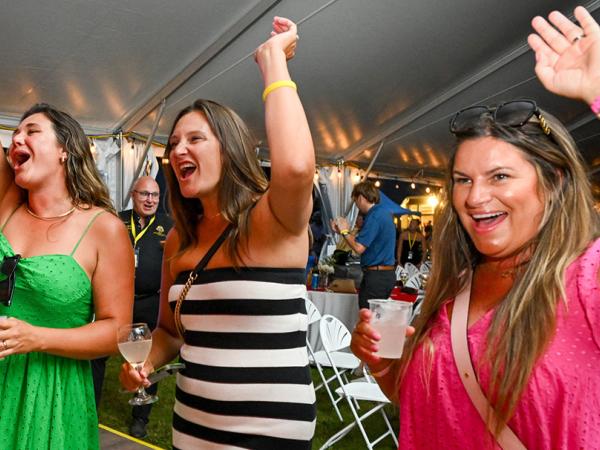 Three women are very happy waving with their arms