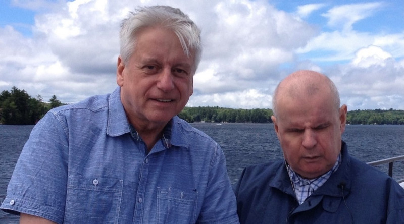 Rob Froom (left) standing waterside at Lake Joe with his brother David Froom. Rob is holding his brother's hand.