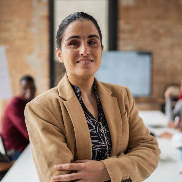 Women stands smiling in a board room