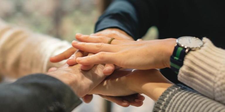 hands stacked on top of each other in a circle