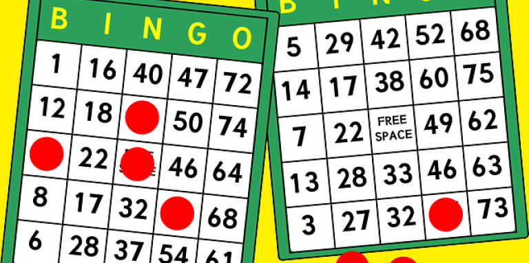 An illustration of two bingo cards and red, circular, chips marking the card. 