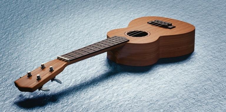 A Ukulele rests on the floor. 