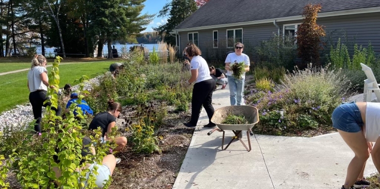 A team of people are weeding and working in the sensory garden.