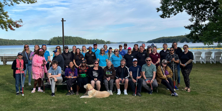 Program attendees and staff posing on the grass at Lake Joe.