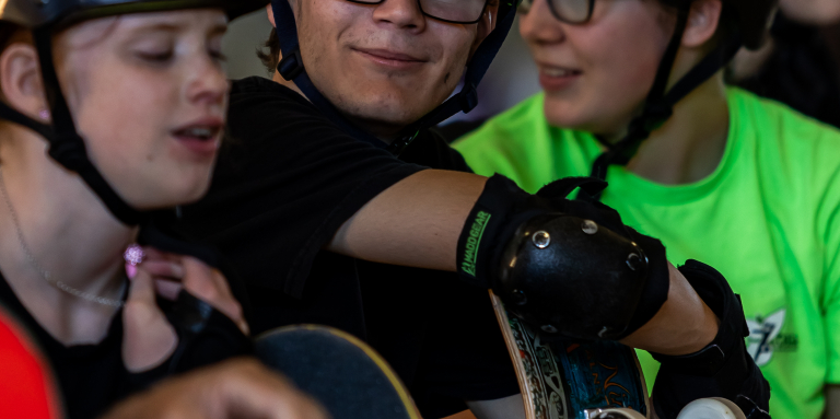  Skateboarders smiling wearing their helmets.