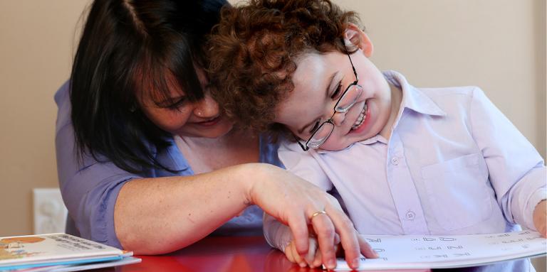 Mother and son reading a braille book