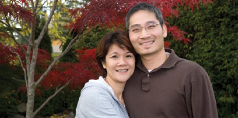 middle-aged couple standing outside smiling