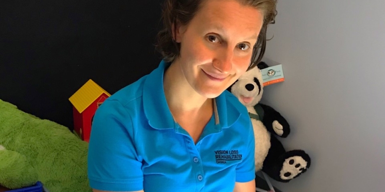 In this photo is Mindy Bodnarchuk, the child and Family Services Counsellor for Northern Saskatchewan. She is sitting on the floor of her office using her light box which she uses for assesments and training with her clients. Stuffed animals and toys are visible in the background.
