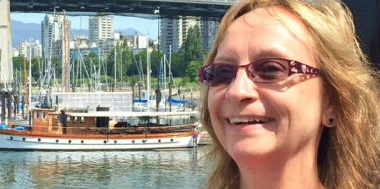 Anna Bradburn stands in front of a harbor and bridge