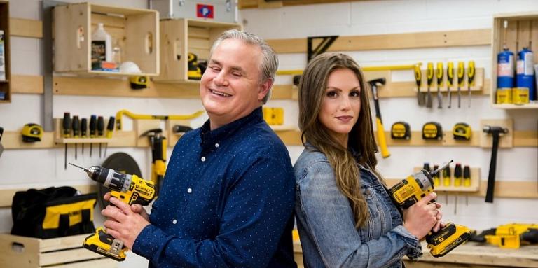 The hosts of Eyes for the Job stand back to back holding power drills 