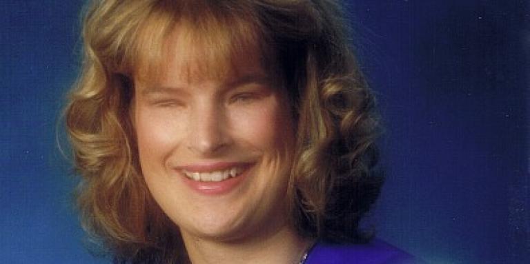 Holly Bartlett wearing a graduation gown, smiling 