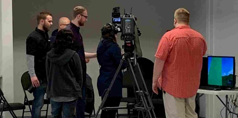 News camera films a youth with virtual reality goggles on