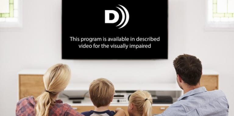 A family of four sitting on a couch, watching TV.