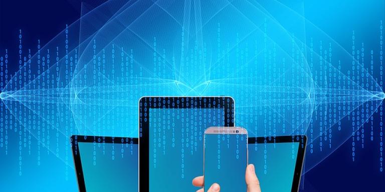 A mixed medium design featuring three tablets, a hand holding a smartphone and a vibrant blue background with a faint overlay of random coding numbers.