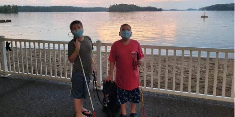 Mason (left) and Ollie (right) and Buddy Dog Hope pose for a picture at Lake Joe. They are wearing face masks and holding their white canes.