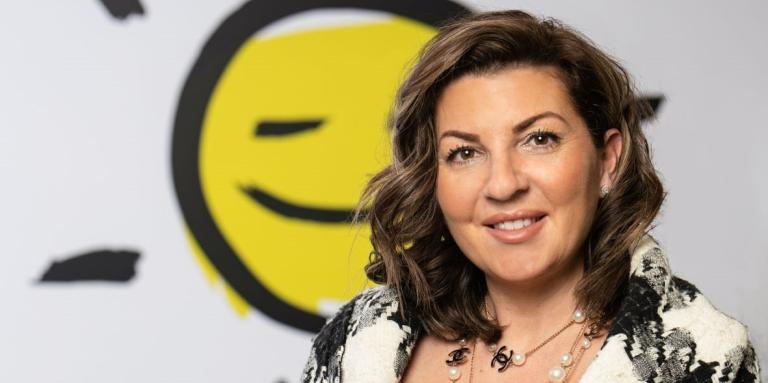 Angela Bonfanti smiling and leaning against a desk