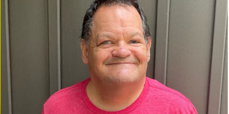 A headshot of a Shawn. He is smiling and wearing a red CNIB Lake Joe t-shirt.