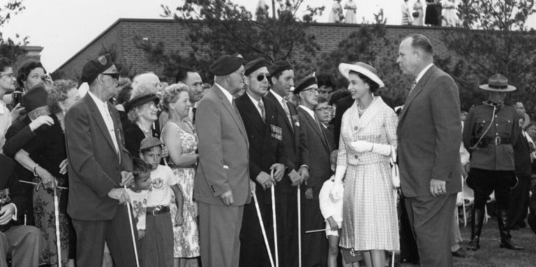Her Majesty Queen Elizabeth II meets with CNIB’s then-president Ralph Misener and veterans with sight loss in CNIB’s fragrant garden, Toronto, 1959.