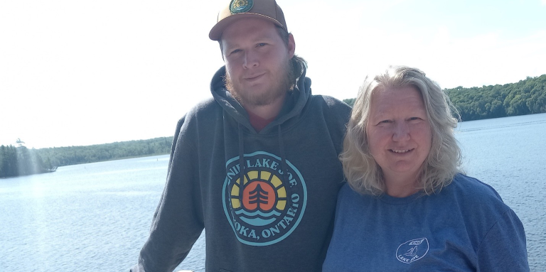 Kathy and her son Clayton stand on a waterfront balcony at their cottage.