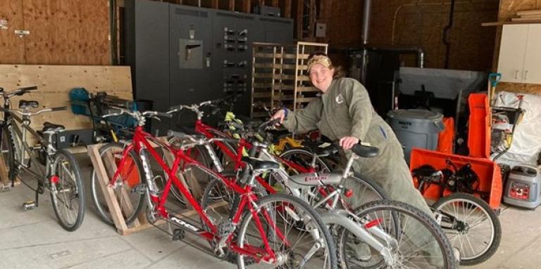 Jessica in the shed at CNIB Lake Joe, wearing her coveralls while she takes care of the fleet of red tandem bicycles.