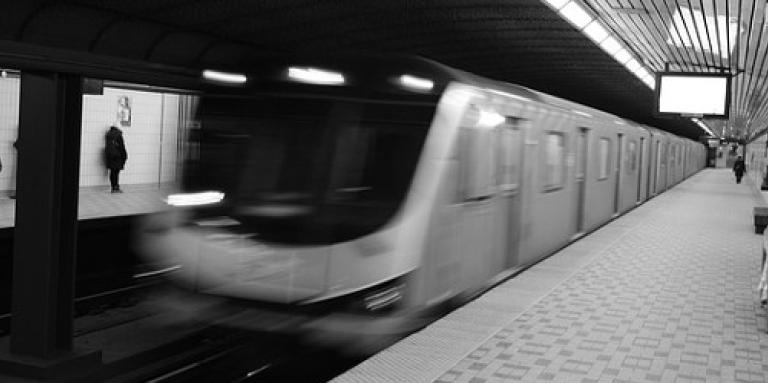 A blurry subway car breezes into a station.