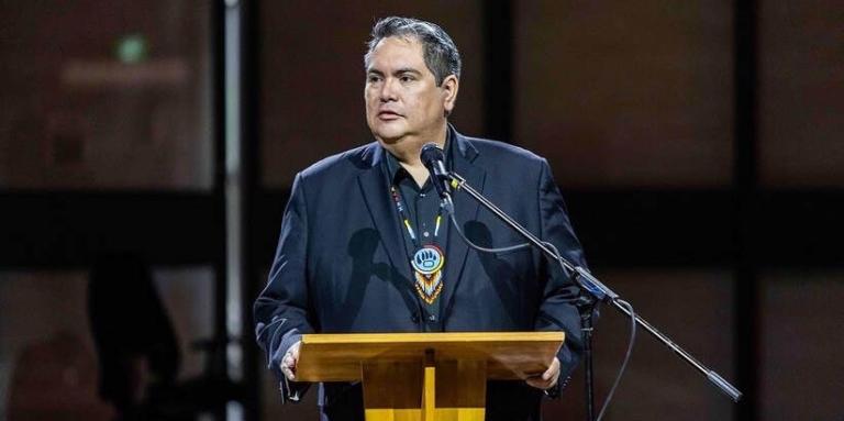 Kyle Mason stands at a podium.